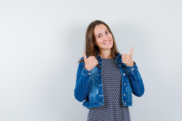 Glimlachende jonge vrouw die een goed handengebaar op witte achtergrond toont