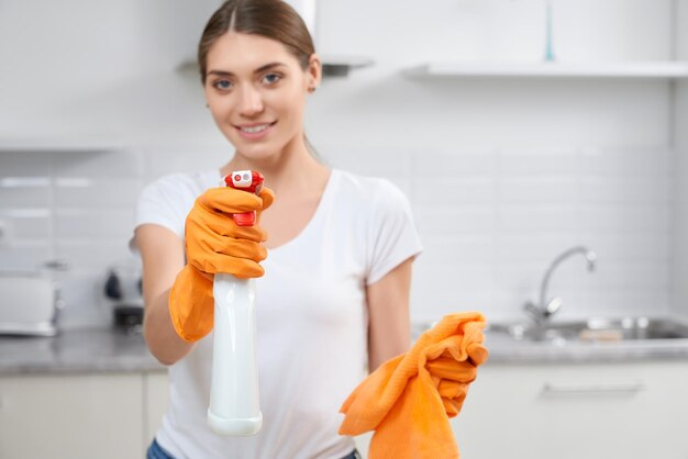 Glimlachende jonge vrouw met oranje vod en wasmiddel