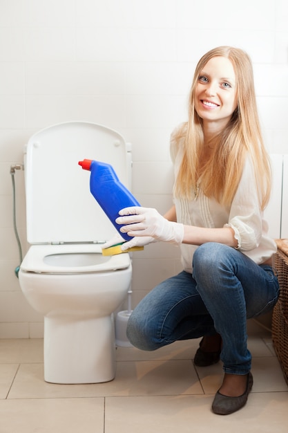 Glimlachende langharige vrouw schoonmaak toilet