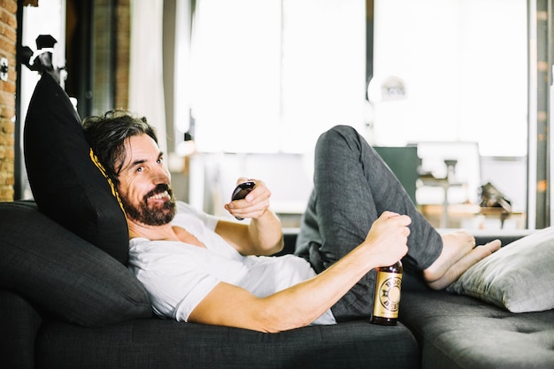 Glimlachende man met bier genieten van tv