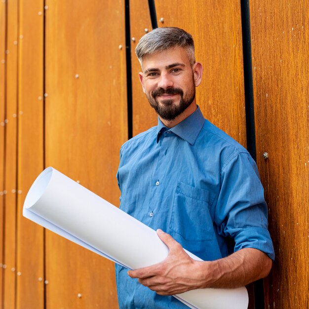 Glimlachende man met blauw shirt en schema's