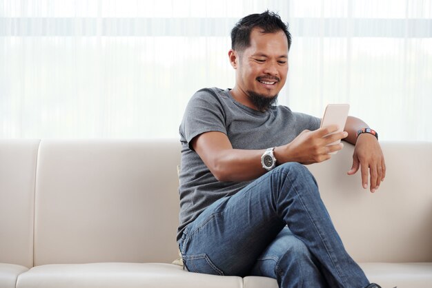 Glimlachende man zijn telefoon controleren