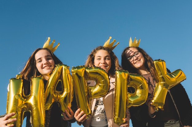 Gratis foto glimlachende meisjes met gelukkig schrijven