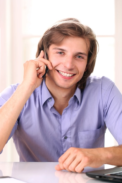 Glimlachende mens die door cellphone spreekt