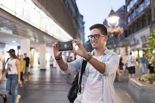 Glimlachende mens die selfie uit mobiele telefoon nemen