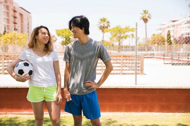 Glimlachende multi-etnische tieners die elkaar op stedelijke achtergrond bekijken