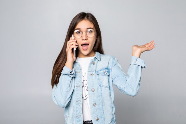 Glimlachende onderneemster die op telefoon spreekt, die op witte muur wordt geïsoleerd