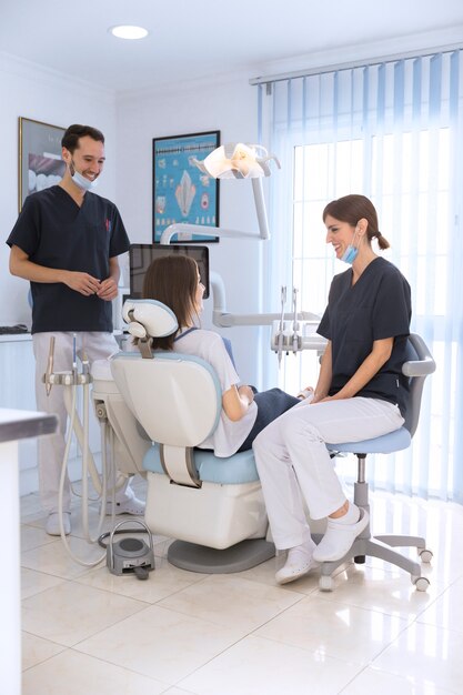 Glimlachende patiënt en tandarts in tandkliniek