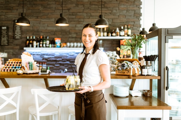 Glimlachende serveerster met cocktail