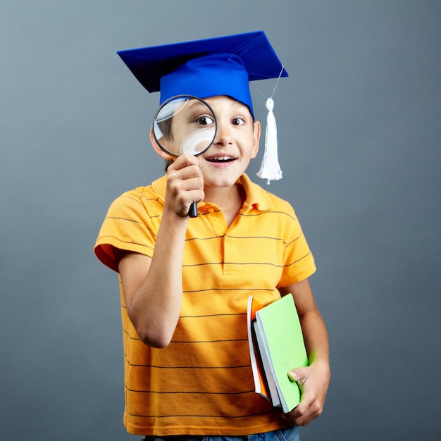 Glimlachende student spelen met zijn vergrootglas