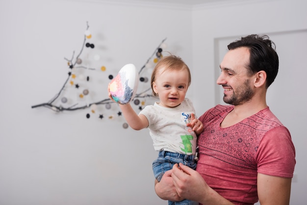 Gratis foto glimlachende vader die zijn zoon bekijkt