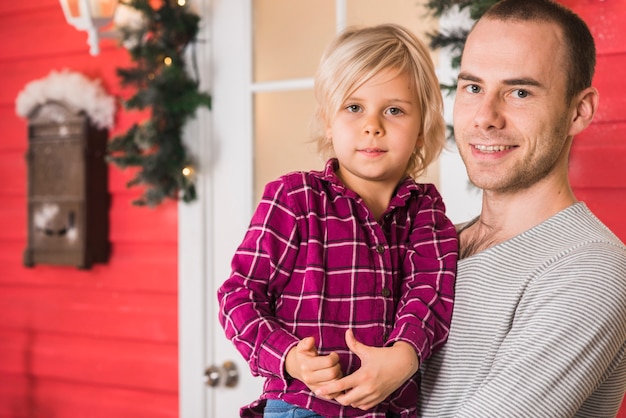 Gratis foto glimlachende vader en dochter het vieren kerstmis