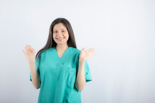 Glimlachende verpleegster die haar hand omhoog houdt en kijkt