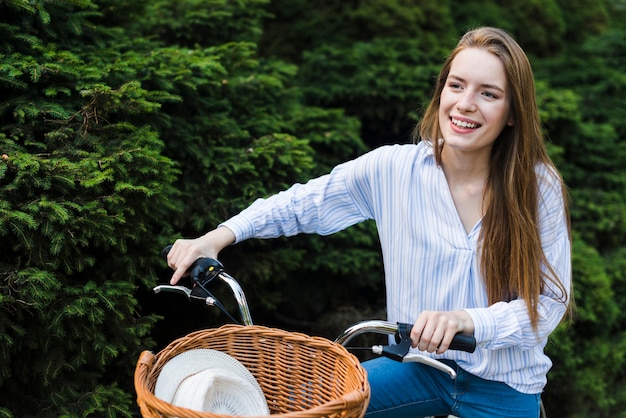 Gratis foto glimlachende vrouw die een fiets berijdt
