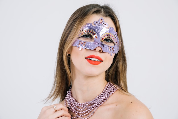 Gratis foto glimlachende vrouw die het venetiaanse masker van maskeradecarnaval dragen