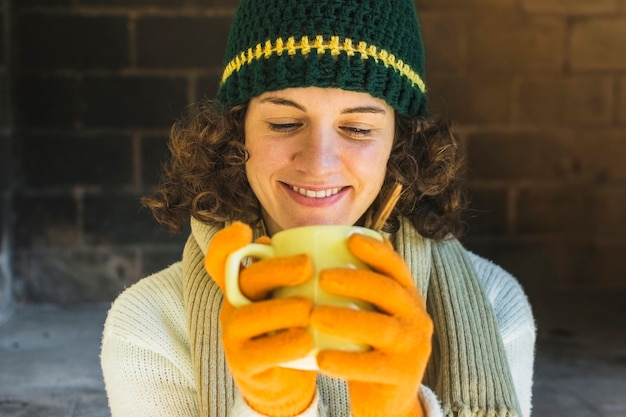 Glimlachende vrouw die hete drank drinkt