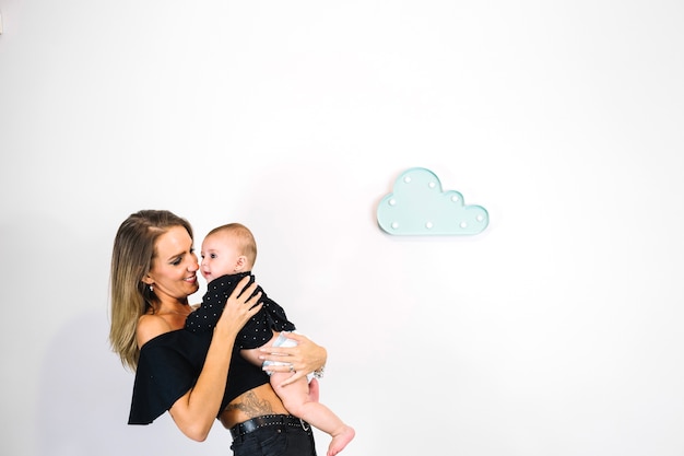 Glimlachende vrouw die leuke baby knuffelt