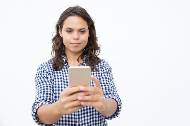 Glimlachende vrouw die mobiele telefoon met behulp van