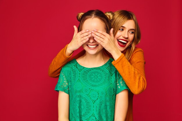 Glimlachende vrouw die ogen behandelt met handen aan haar vriend