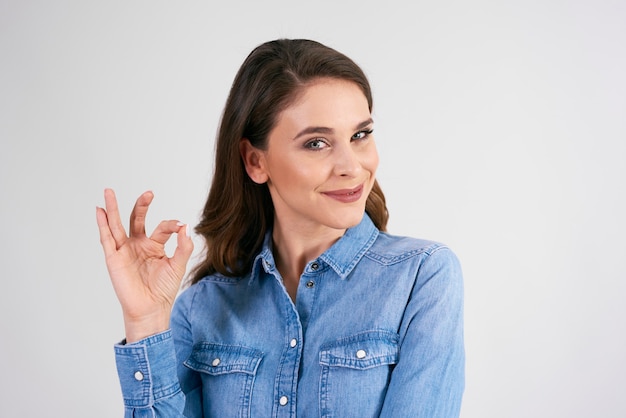 Gratis foto glimlachende vrouw die ok teken toont