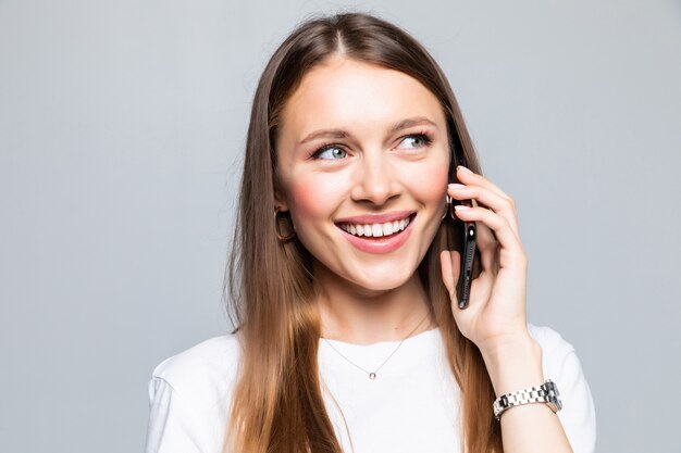 Glimlachende vrouw die op de geïsoleerde slimme telefoon spreekt