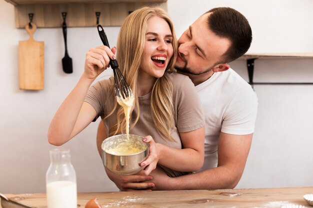 Glimlachende vrouw en man die samen koken