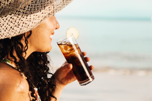 Glimlachende vrouw het drinken koeldrank