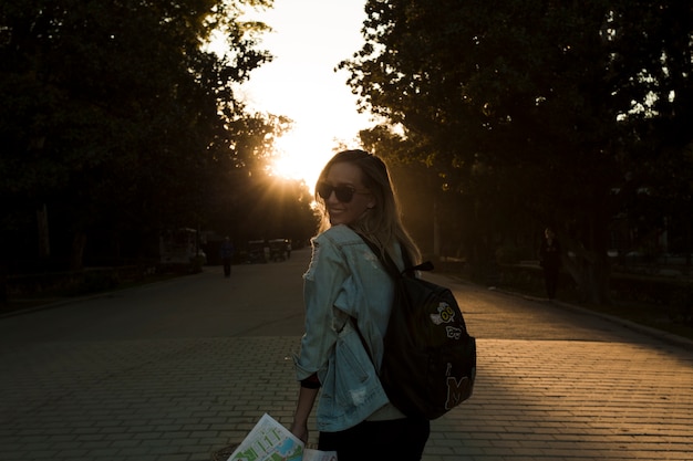 Glimlachende vrouw in park op zonsondergang