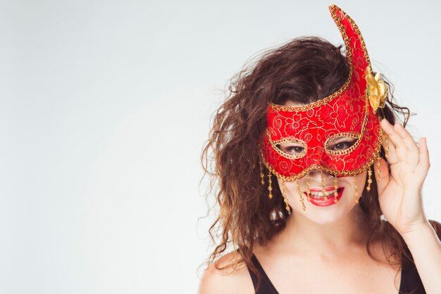 Glimlachende vrouw in rood mooi masker