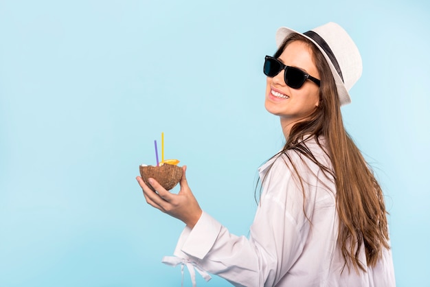 Glimlachende vrouw in zonnebril met drank