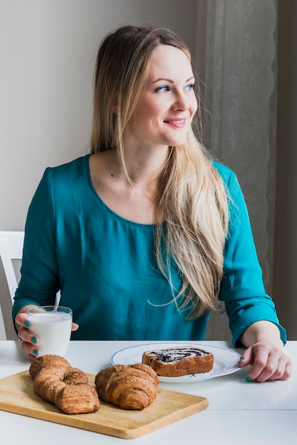 Glimlachende vrouw met melk die weg eruit ziet