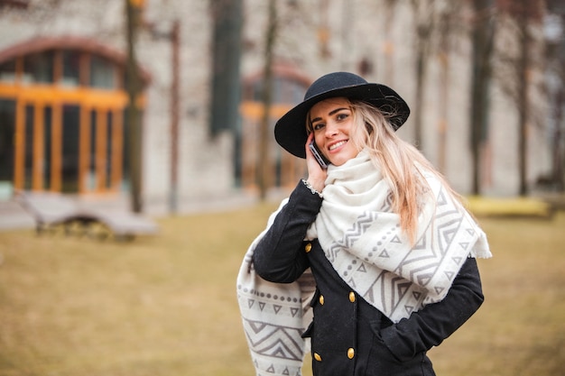 Glimlachende vrouw met sjaal en hoed