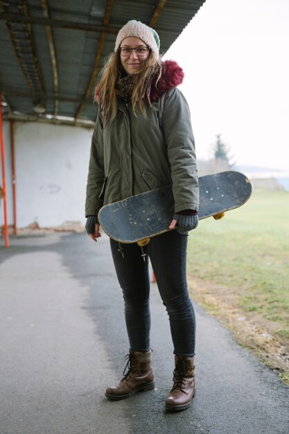 Glimlachende vrouw met skateboard