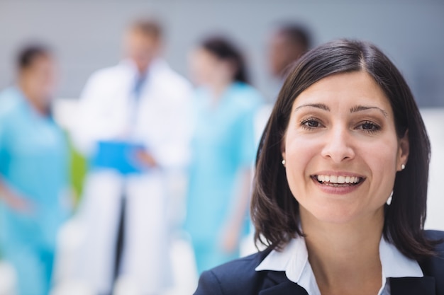 Glimlachende vrouwelijke arts in het ziekenhuispand