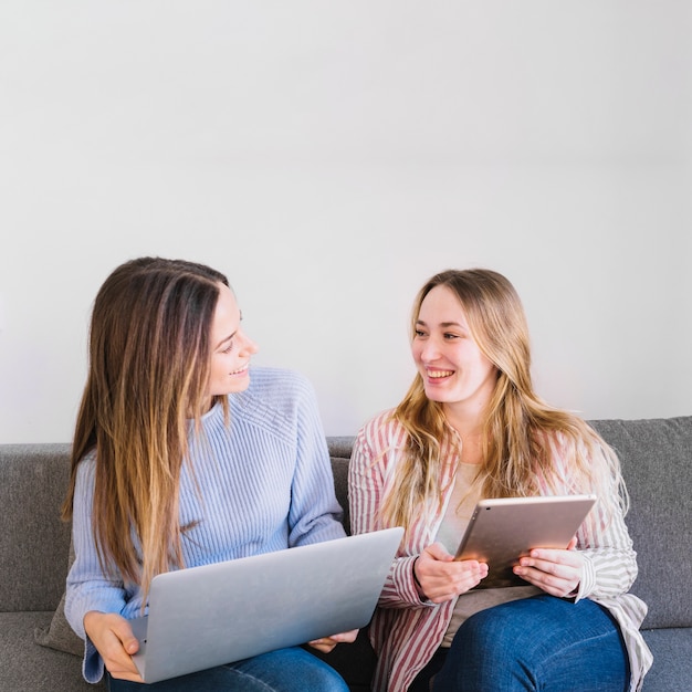 Glimlachende vrouwen met technologieën