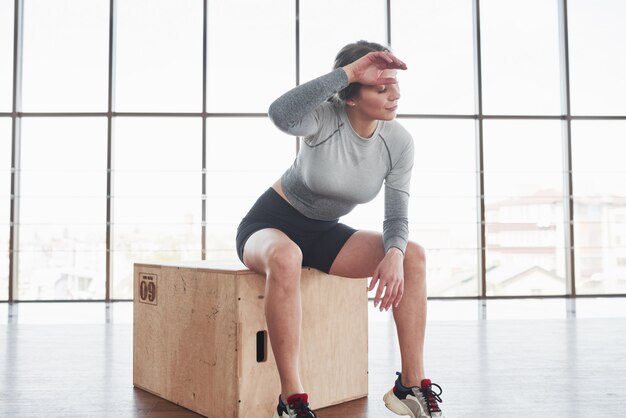 Goed gedaan. Sportieve jonge vrouw heeft fitnessdag in de sportschool in de ochtendtijd