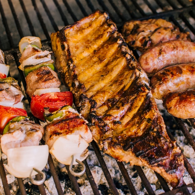 Goed gegrilde stukjes vlees en groenten op grill houtskool