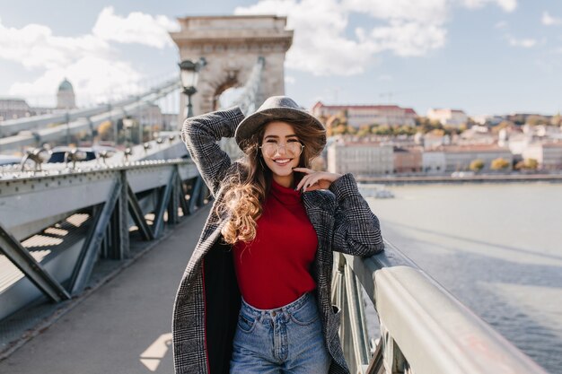 Goed geklede vrouw in glazen die de brug afloopt