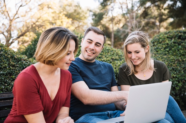 Goede vrienden met behulp van laptop in park