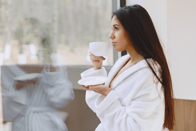 Goedemorgen. Vrouw drinkt koffie. Dame bij het raam.