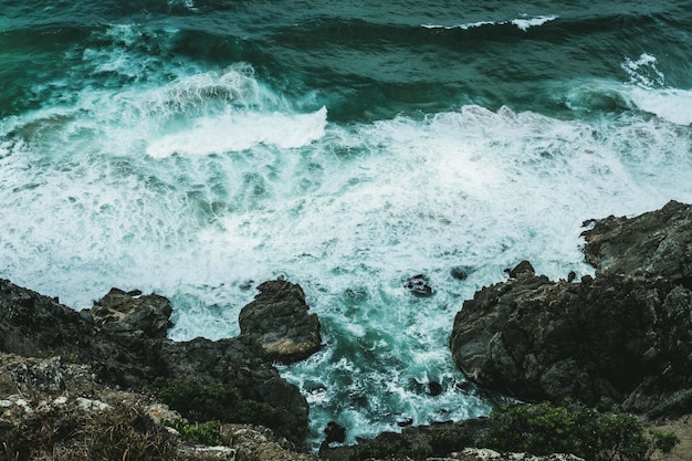 Gratis foto golven raken de rotsen aan de oever van de oceaan