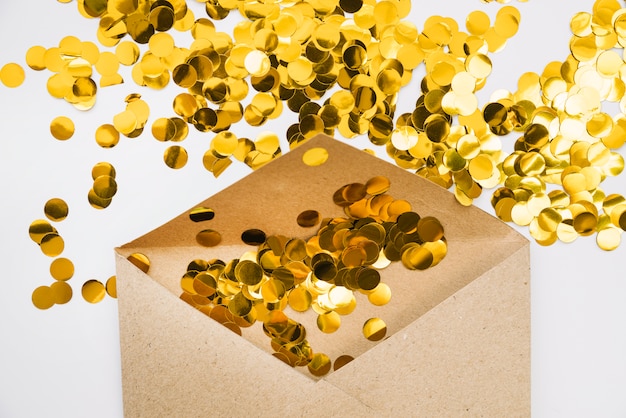 Gouden confetti in papieren envelop