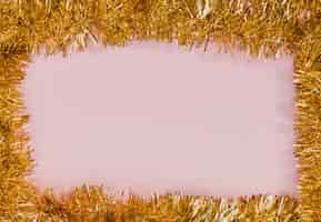Gratis foto gouden klatergoudframe met roze achtergrond