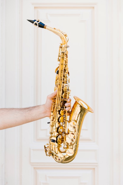 Gouden saxofoon die door persoon wordt gehouden