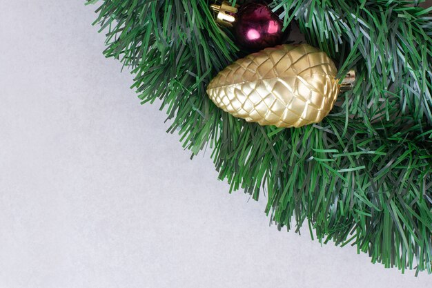 Gouden stuk speelgoed van pinecone op groen klatergoud op witte oppervlakte