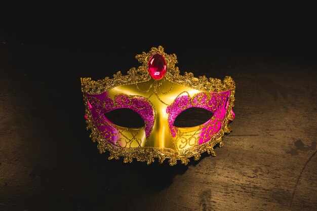 Gouden Venetiaans masker op een houten tafel