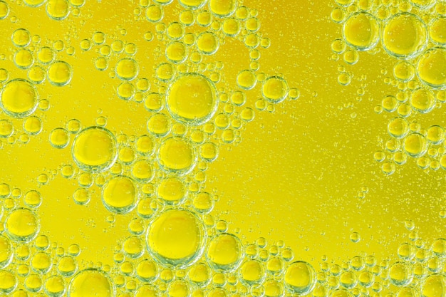 Goudgele bellenolieolieversterker water abstracte achtergrond groene macro
