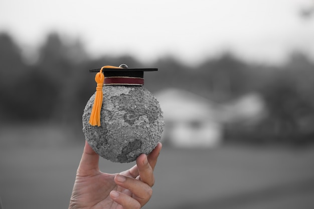 Graduation cap op studenten die grijs papier mache ambacht earth globe Premium Foto