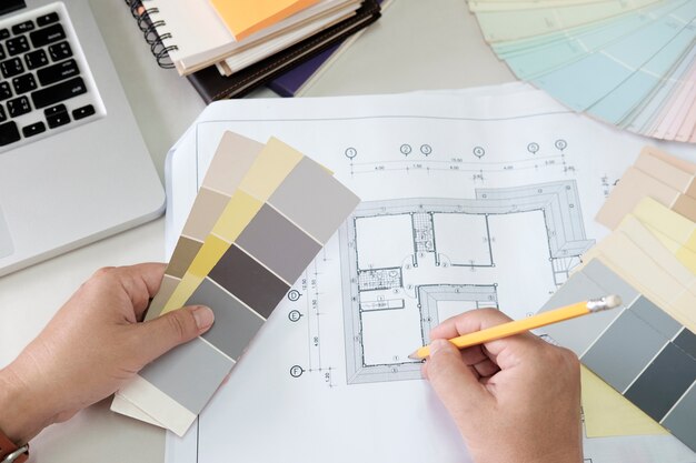 Grafisch ontwerp en kleurstalen en pennen op een bureau. Architectonische tekening met werkgereedschap en accessoires.