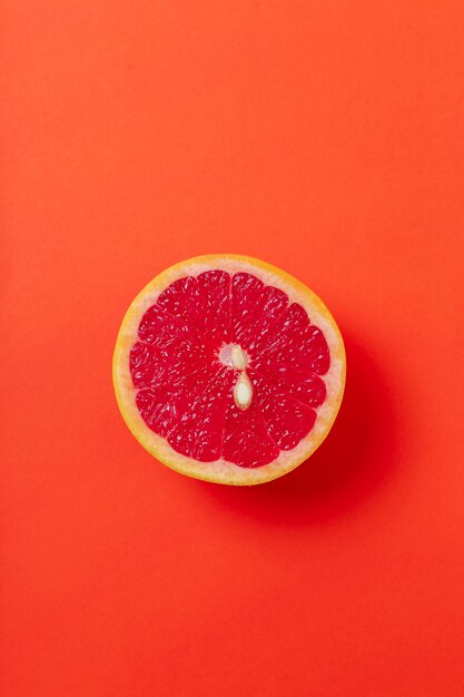 Grapefruit segment geïsoleerd op rode ondergrond